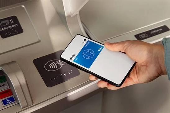 A smartphone wallet held near an ATM contactless reader